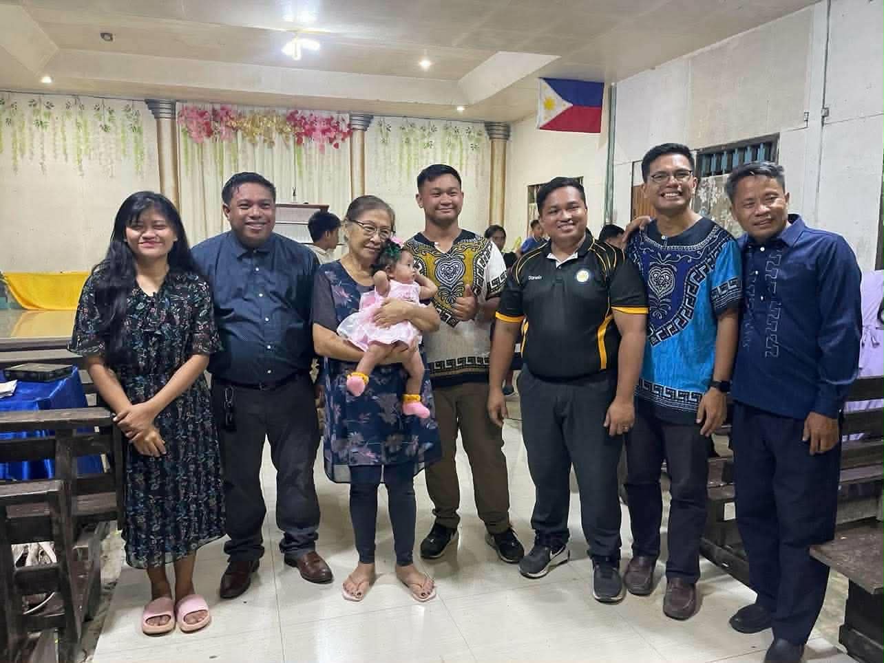 Visitors standing together for a photograph inside a church hall
