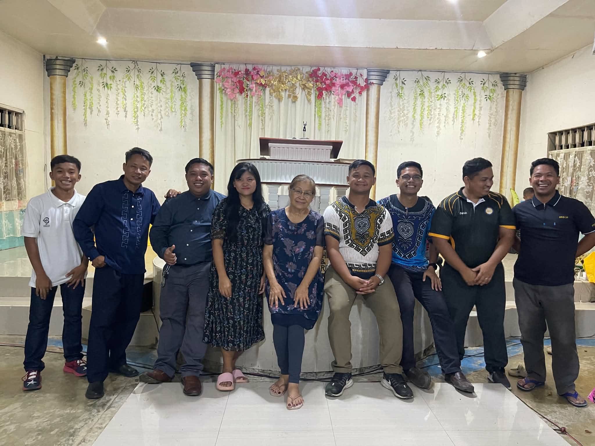 A group of visitors posing together inside a church hall