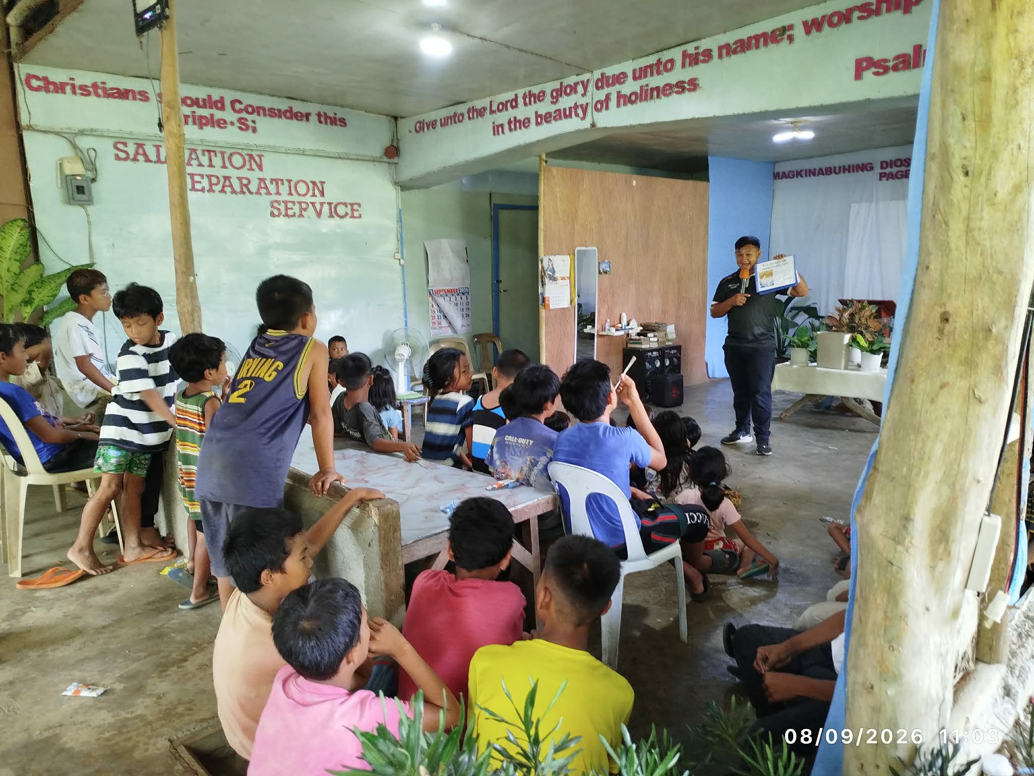 Adults and children gathered around tables inside a church