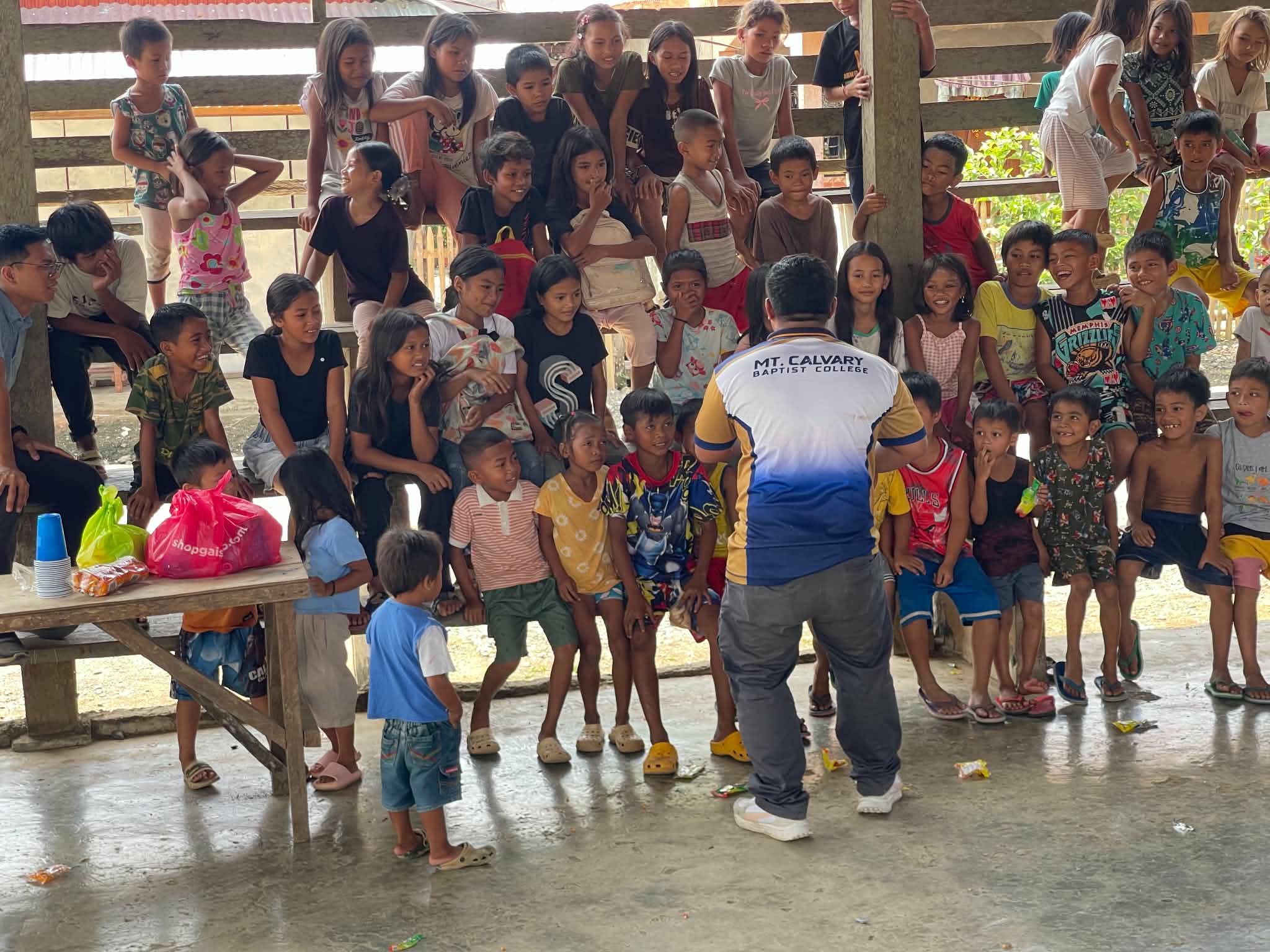 Children and adults posing together inside a wooden gathering space