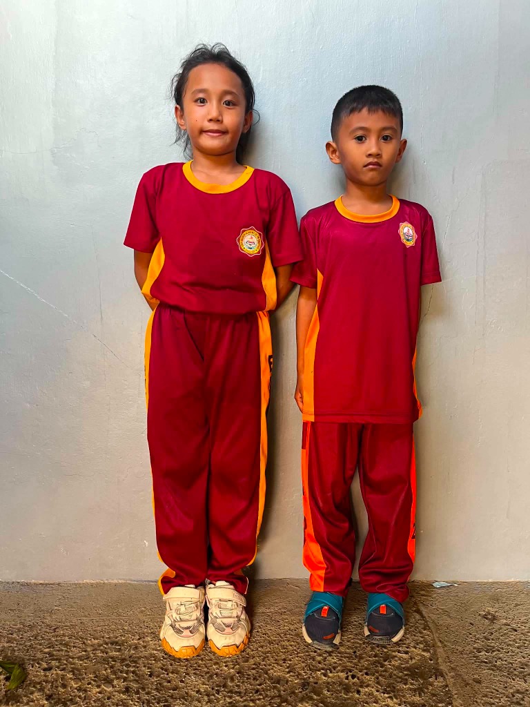 Young elementary students wearing maroon and yellow Ezra Mission Academy uniforms