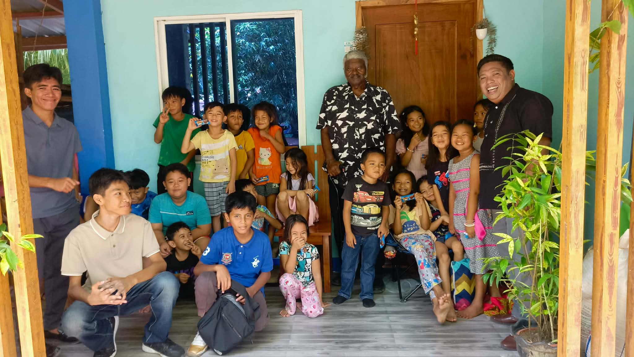 Missionary Henry Walker surrounded by children and young ministry helpers