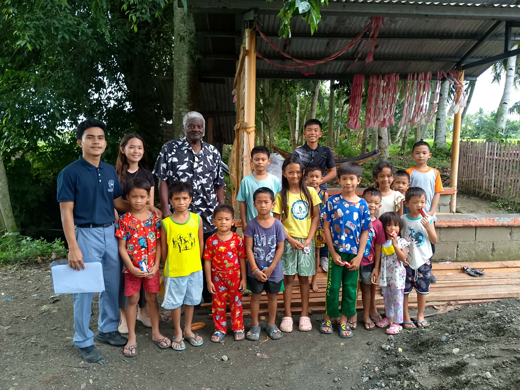Missionary Henry Walker and ministry workers with a children's class