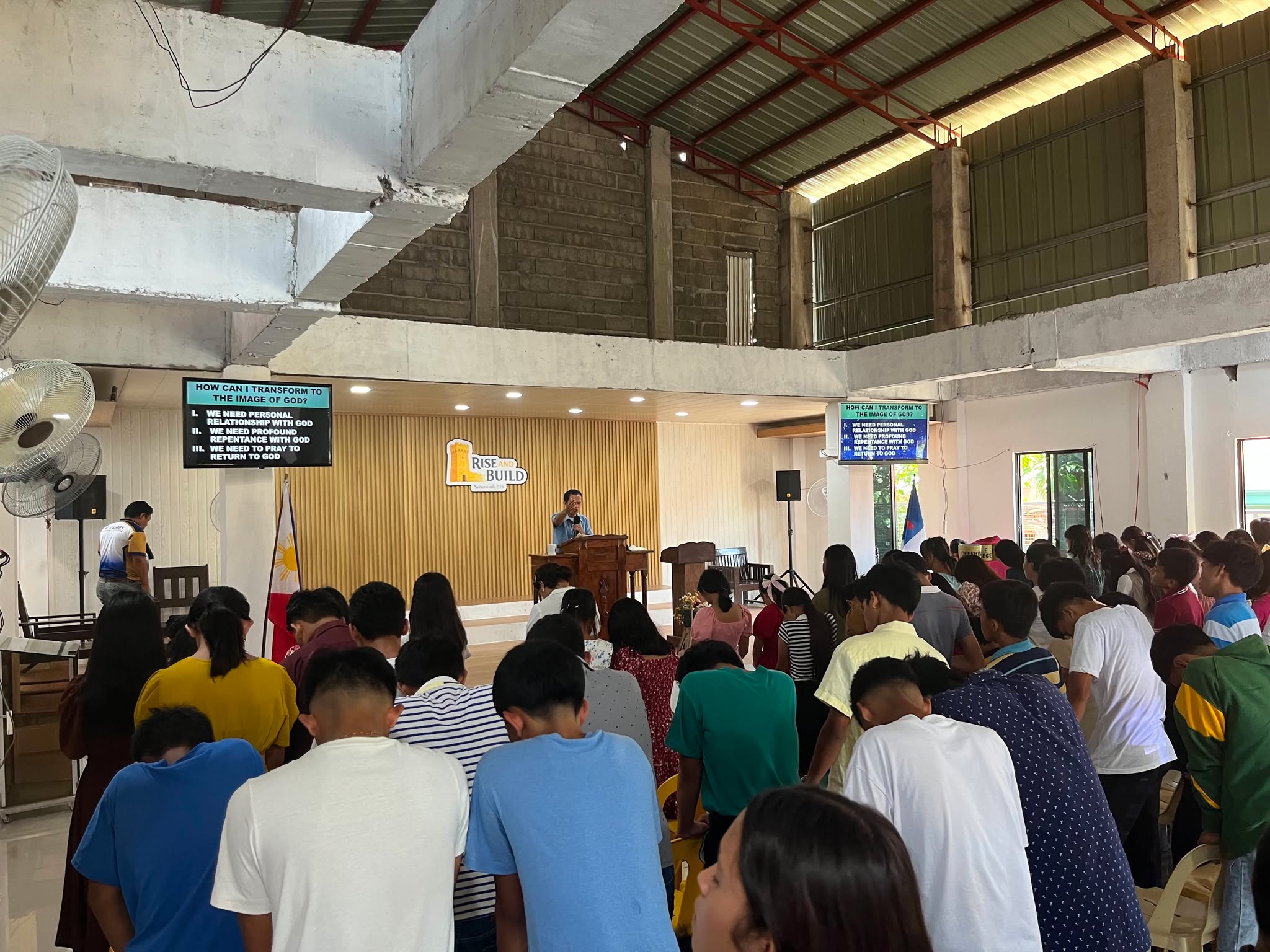 Young people bowing in prayer during the message at the youth fellowship