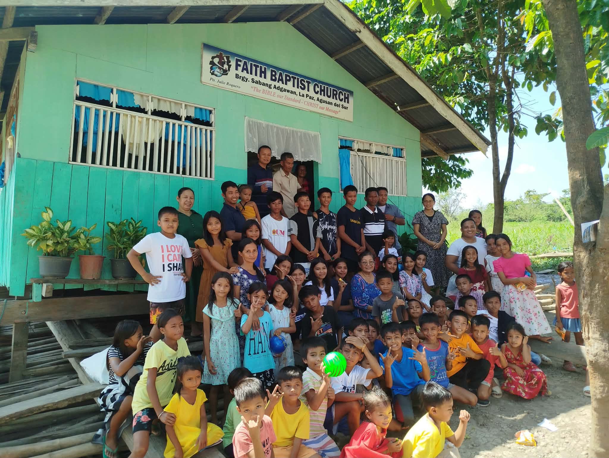Children and adults gathered together outside a community church