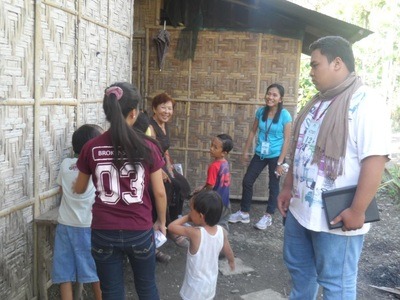 ECAMPI ministry workers and community members gathered outside a bamboo shelter